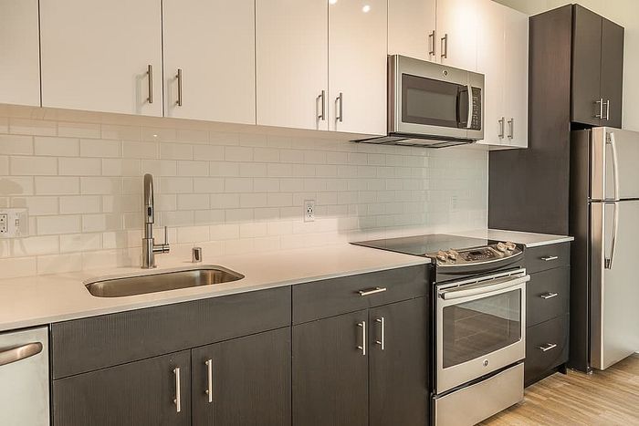 Modern kitchen with sleek stainless steel appliances, glossy cabinetry, and elegant subway tile backsplash.
