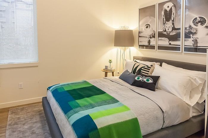 Cozy bedroom featuring a modern design with a comfortable bed, stylish pillows, and a chic lamp, perfect for relaxation.