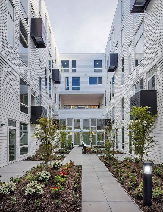 Modern apartment courtyard with lush landscaping, elegant pathways, and sleek architectural design offering tranquil living.