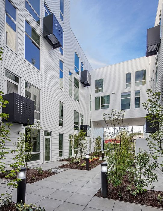 Modern apartment complex showcasing a beautifully landscaped courtyard with sleek architectural design and abundant natural light.