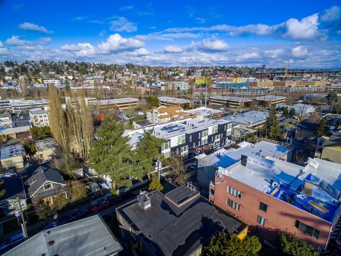 Vibrant urban neighborhood with scenic views, modern buildings, and lush greenery under a bright blue sky.