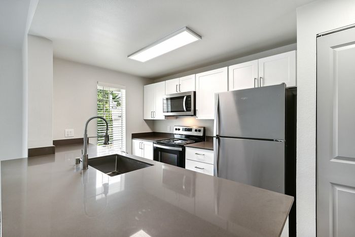 Modern kitchen with sleek countertops, stainless steel appliances, and abundant natural light.