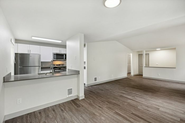 Modern open-concept kitchen and living area with sleek finishes and hardwood floors, perfect for entertaining.