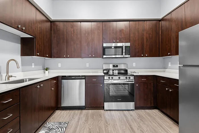 Modern kitchen with sleek dark wood cabinetry, stainless steel appliances, and elegant countertops.