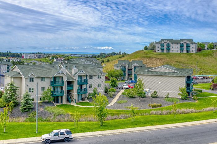 Charming hillside apartments with lush green landscaping and scenic views, perfect for tranquil living.