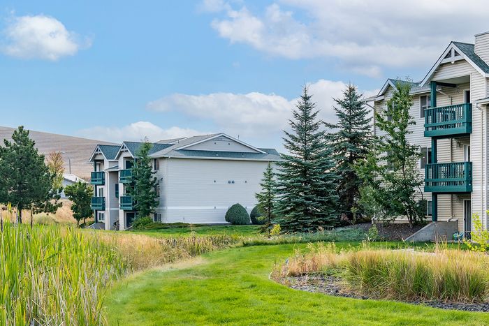 Charming apartment complex with lush gardens and serene walking paths, offering a perfect blend of nature and community living.