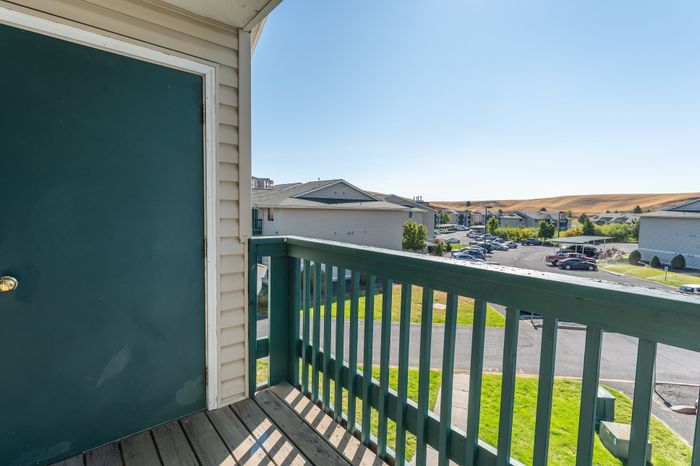 Inviting entryway balcony showcasing scenic views of a peaceful neighborhood with rolling hills in the distance.