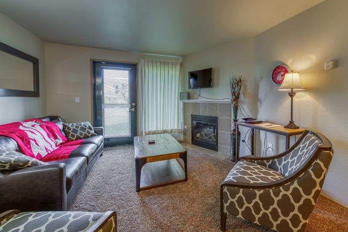Cozy living room with modern furniture, vibrant decor, and a warm fireplace, perfect for relaxation and entertainment.