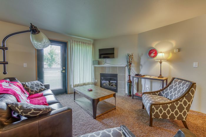 Inviting living room featuring a cozy fireplace, stylish seating, and a contemporary design with natural lighting.