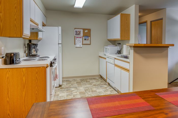 Inviting kitchen with modern appliances, warm wood cabinetry, and sleek countertops, perfect for culinary adventures.