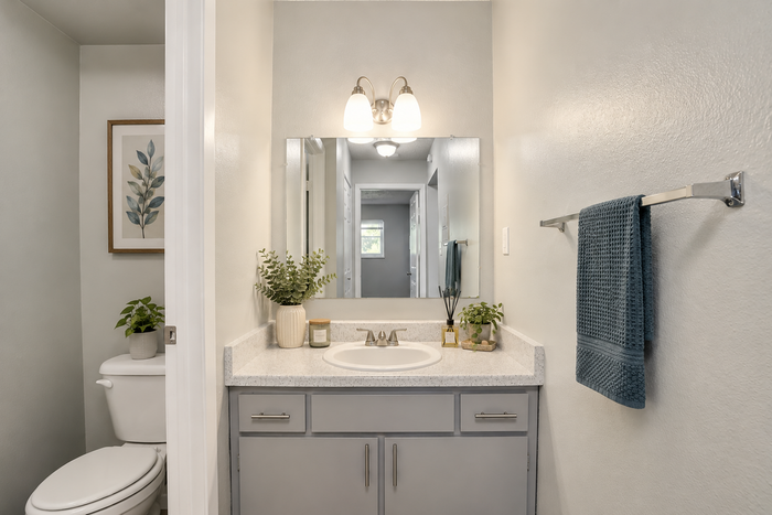 Elegant bathroom showcasing modern countertop with stylish décor and a sleek mirror, perfect for a serene start to your day.