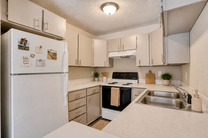 Chic kitchen with modern white cabinets, spacious countertops, and sleek appliances, offering a cozy and functional cooking space.