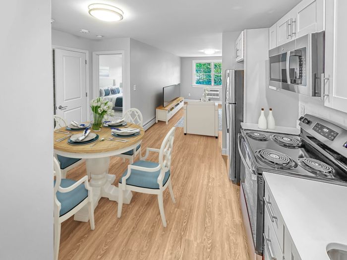 Kitchen with stainless steel appliances and adjacent dining area in a staged apartment at Westgate Arms in Salem, New Hampshire