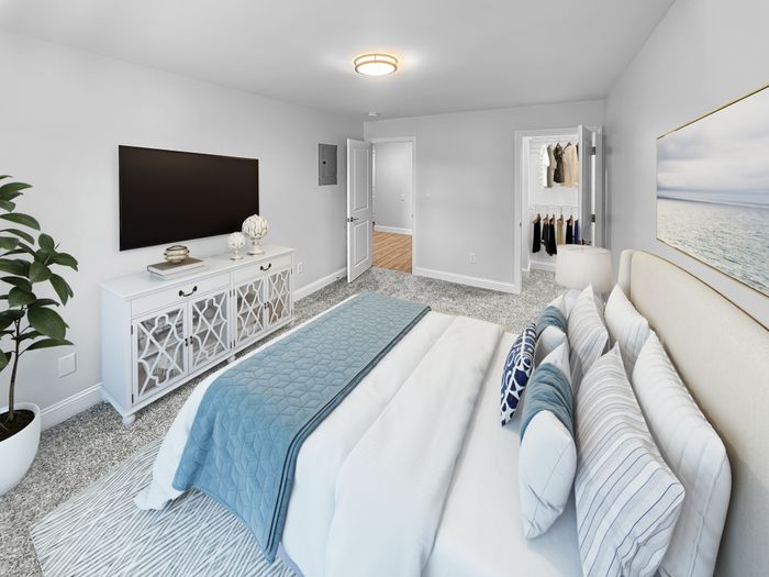 Bright bedroom with plush carpeting, large bed, and spacious closet at Westgate Arms in Salem, New HampshireStaged Photo