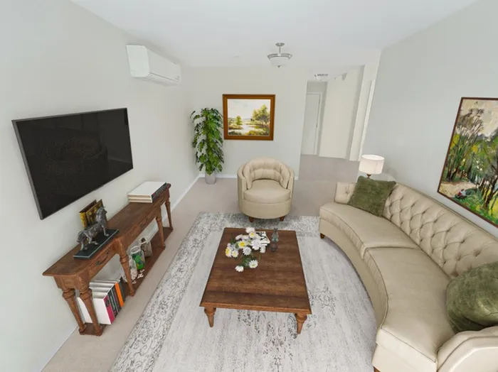 Airy and comfortable apartment living room with cozy seating at Allard’s Grove in Dracut, MA