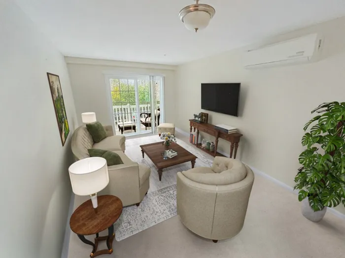 Sun-lit apartment living room with balcony access and comfortable seating at Allard’s Grove in Dracut, MA