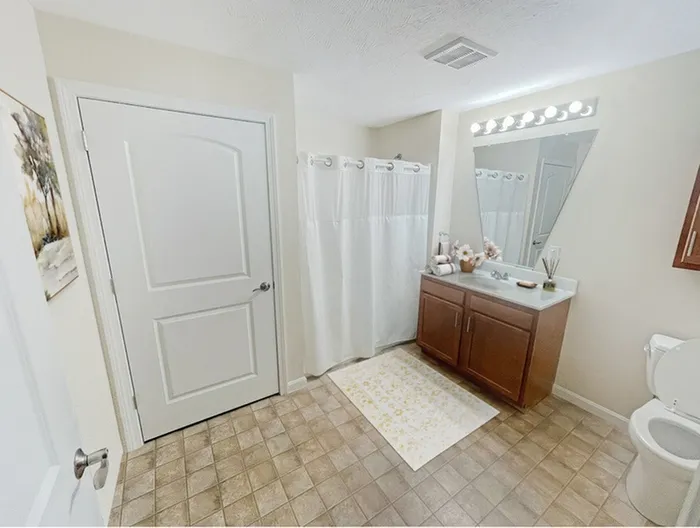 Bright and spacious apartment bathroom with large vanity and tub shower at Allard’s Grove in Dracut, MA