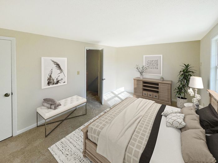 Bedroom with carpeted flooring, closet access, and natural light at Meadowbrook Village in Gardner, Massachusetts