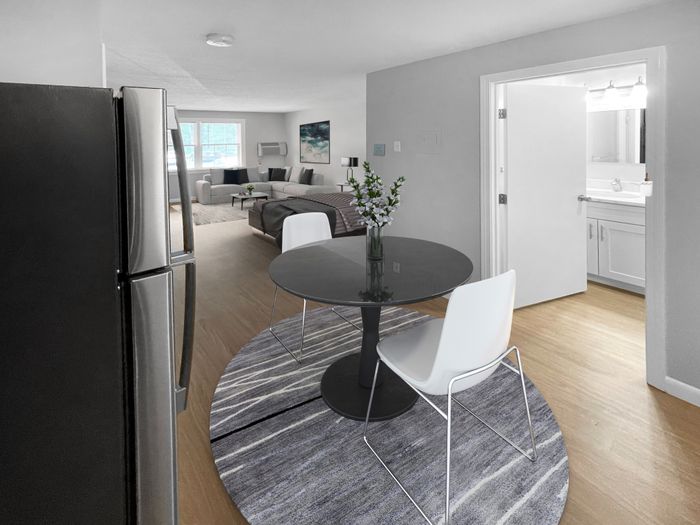 Apartment dining area and living room with natural light at Woodlands at Nashua in Nashua, NH