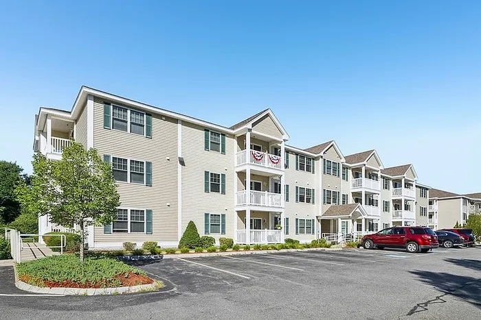Charming and well-maintained apartment building exterior with balconies at Allard’s Grove in Dracut, MA