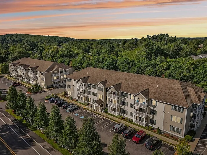 Scenic aerial view of apartment community buildings and surrounding greenery at Allard’s Grove in Dracut, MA