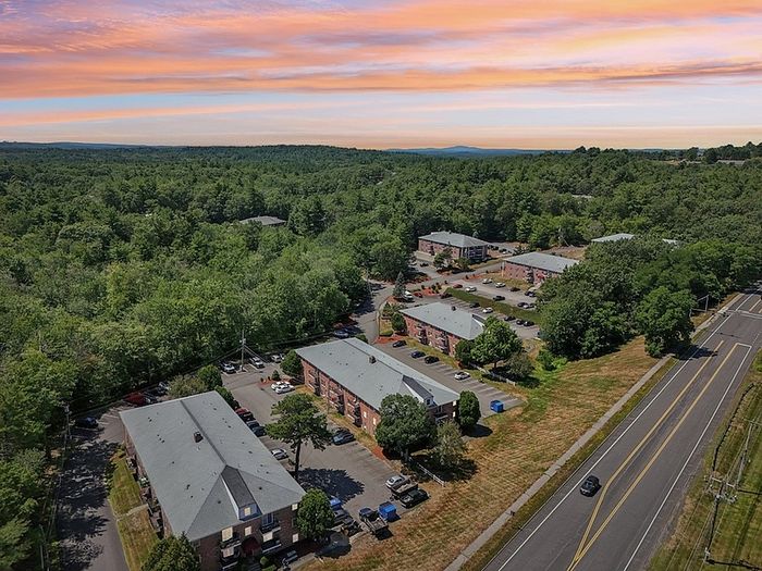 Aerial view of Woodlands at Nashua apartments surrounded by trees near Daniel Webster Highway in Nashua, NH