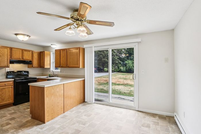 Meadowbrook Village kitchen and adjoining dining area with wood cabinets and sliding glass doors.