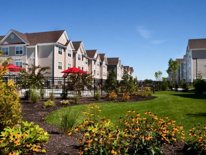 Mt. Laurel Township NJ Pet-Friendly Garden Style Apartments - Laurel Green - Property Exterior with Tan Walls and White Trim, and Lush Landscaping