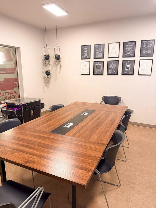 Chic meeting room with modern wooden table, stylish chairs, and contemporary wall art.