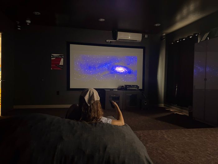 Luxurious home cinema room with large screen, cozy seating, and ambient lighting for an ultimate entertainment experience.
