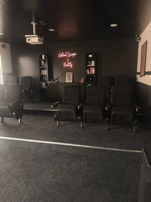 Modern home theater with plush seating and ambient lighting, featuring a vibrant neon sign for an immersive experience.