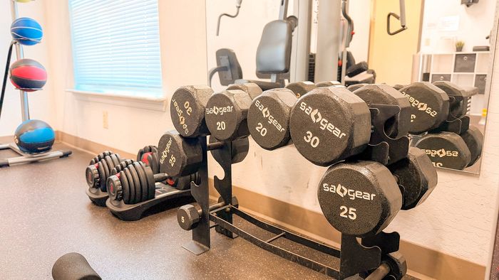 Bright, modern fitness room with a range of dumbbells and vibrant medicine balls, perfect for an energizing workout.