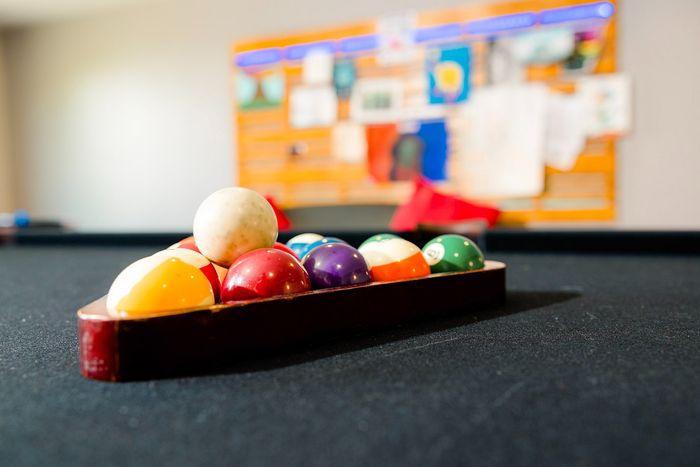 Chic billiards room with a vibrant rack of colorful pool balls on a sleek felt table, epitomizing leisure and entertainment.