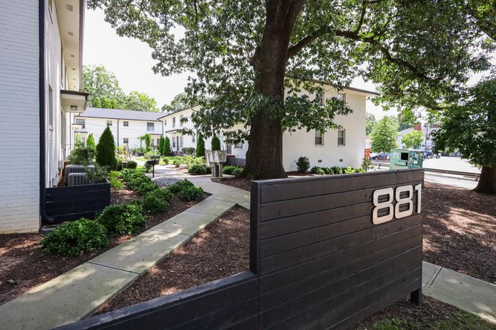Charming apartment complex with lush greenery and welcoming pathways, showcasing harmonious living at 881.