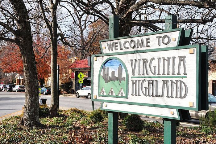Charming Welcome to Virginia Highland sign nestled among trees and cozy neighborhood streets, epitomizing vibrant community living.