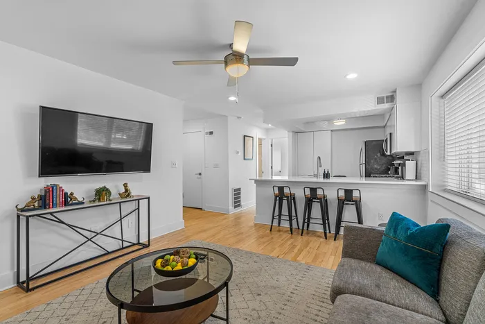 Modern open living space with a sleek kitchen, bar seating, and cozy living area, perfect for entertaining and relaxation.