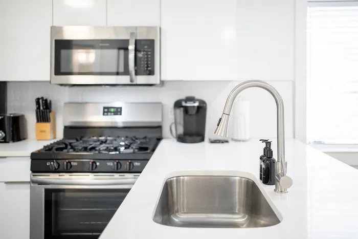 Modern kitchen featuring sleek stainless steel appliances, elegant faucet, and a bright, spacious countertop for gourmet cooking.