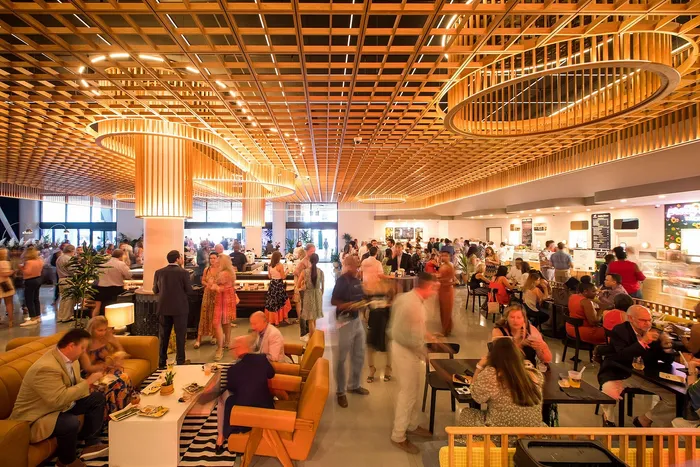 Lively and elegant venue with modern wooden ceiling design, filled with people enjoying conversations and dining.