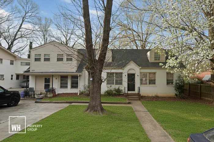 Charming suburban home with a welcoming front yard, beautiful trees, and a cozy porch, offering an inviting atmosphere.
