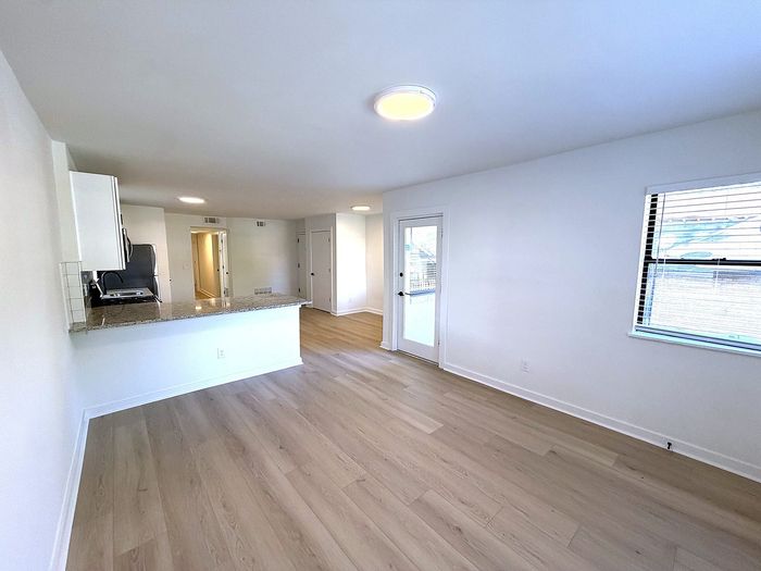 Bright, open-concept living space with modern kitchen, hardwood floors, and ample natural light.
