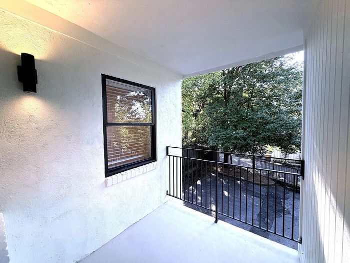 Inviting balcony with elegant lighting, offering serene views of lush greenery and a peaceful outdoor space.