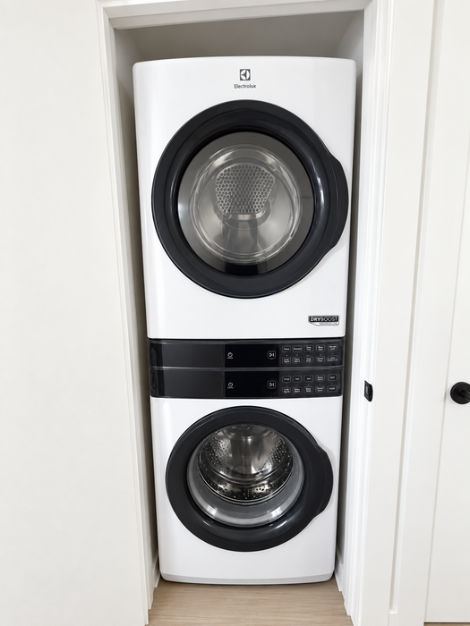 Modern apartment equipped with a sleek stackable washer and dryer set in a compact laundry nook.