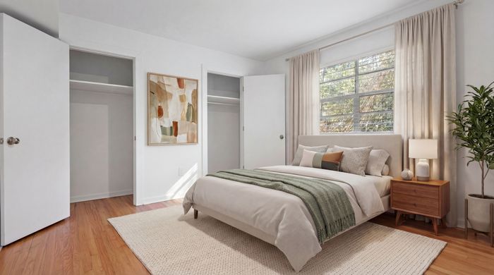 Bright and inviting bedroom with chic decor, featuring a comfortable bed, stylish nightstand, and modern artwork, perfect for relaxation.