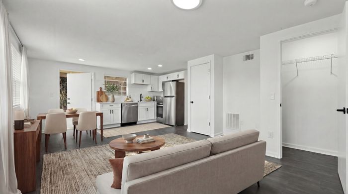 Bright open-plan living space featuring a modern kitchen, cozy dining area, and elegant decor with natural light pouring through spacious windows.