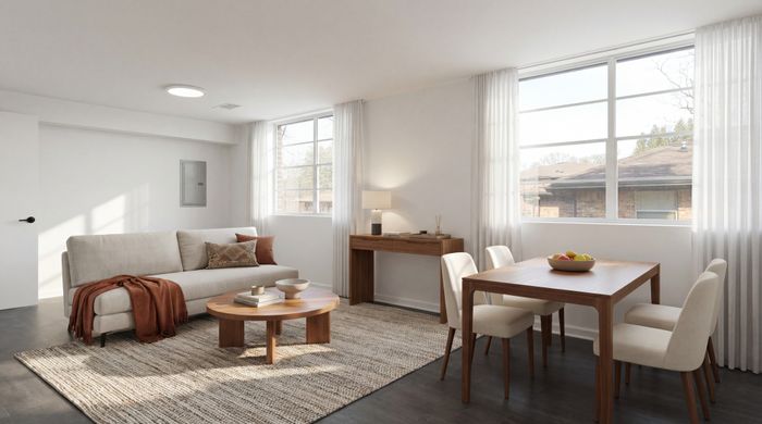 Modern and inviting living room with natural light, featuring a cozy beige sofa, stylish wooden coffee table, and a chic dining area by large windows.