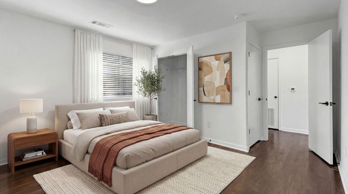 Bright and inviting bedroom with modern decor, featuring a plush bed, stylish wooden nightstand, contemporary art, and elegant hardwood floors.