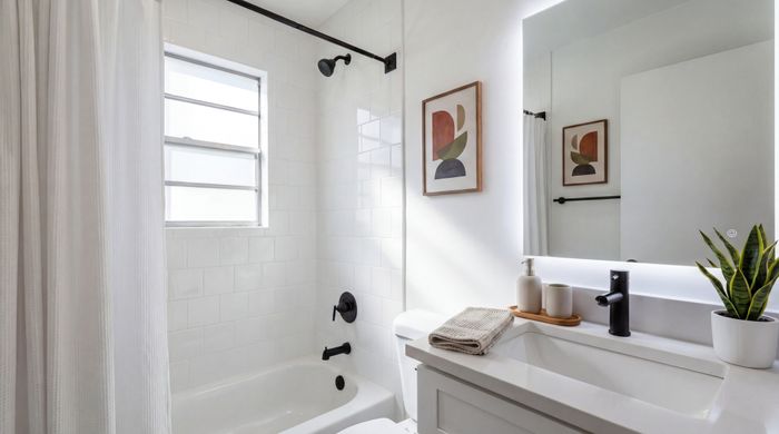 Bright, modern bathroom with sleek fixtures, white tiles, and a large mirror creating an inviting, fresh ambiance.
