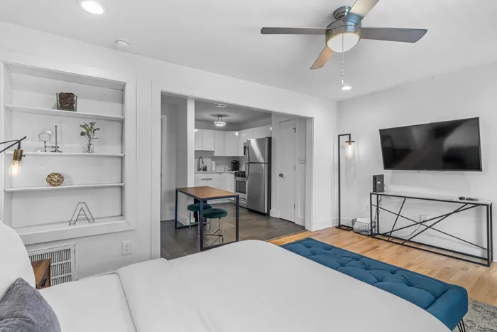 Chic apartment interior showcasing cozy bedroom, sleek modern kitchen, and elegant living space with minimalistic decor.