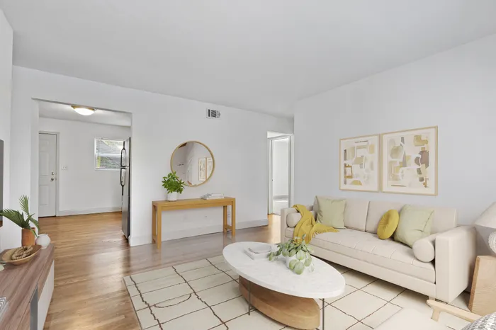 Bright and inviting living room with modern furnishings, stylish decor, and hardwood floors.