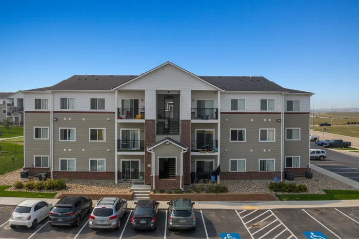Modern apartment building with stylish balconies and ample parking, offering a serene suburban lifestyle.